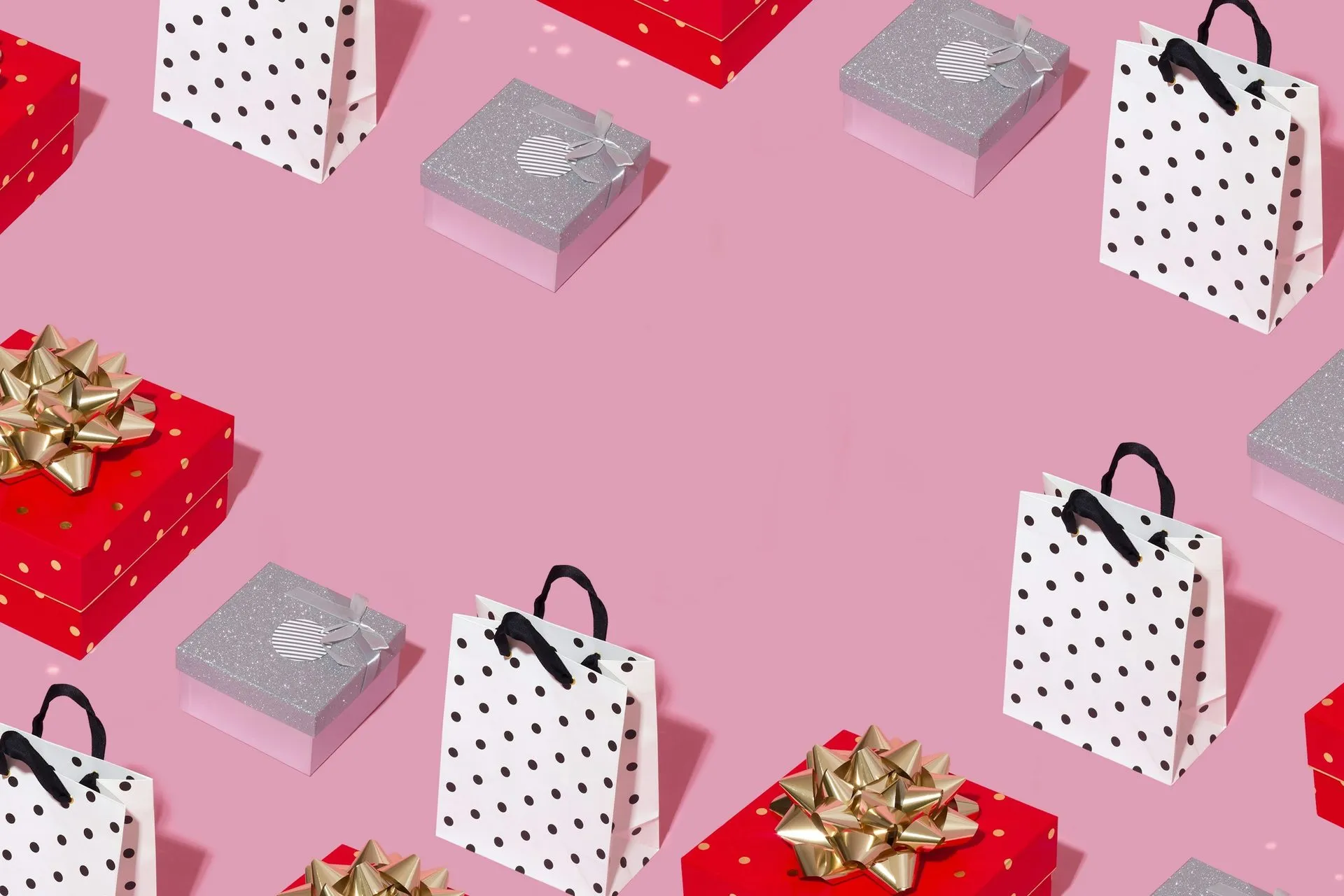 Confezioni regalo colorate disposte su uno sfondo rosa